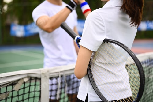 Preview: Two young tennis players in sportswear greeting before a tennis match.