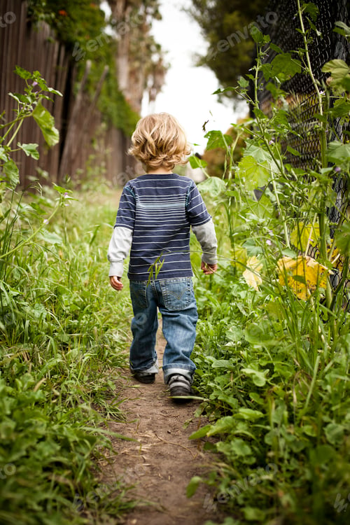 Preview: Boy walking on dirt track rear view