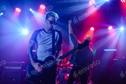 Preview: Guitarist and singer performing live on stage under colorful lights