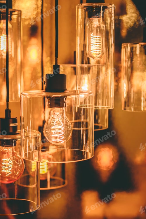Preview: Close up view on a transparent modern lamp with a retro bulb inside it.