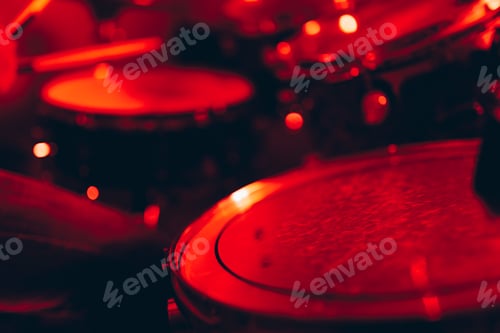 Preview: Man with drumsticks playing on drums in redness
