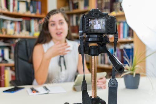 Preview: Young Caucasian female vlogger making a video with a DSLR camera at home