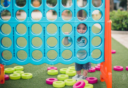 Preview: Baby girl visible from the circle of giant connect 4 game in the park