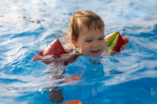 Preview: A boy with armbands and a disgruntled face, trying to get out of a pool of clean water