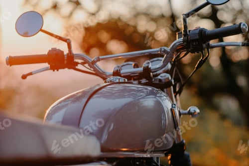 Preview: Shallow focus closeup shot of a motorcycle handlebar during the sunset