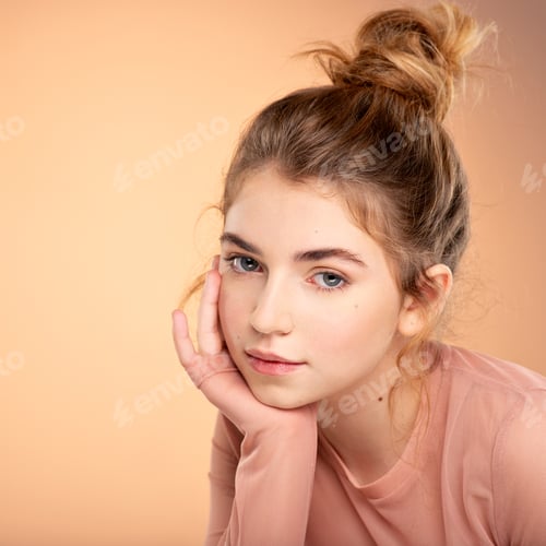 Preview: Closeup portrait of an young girl over colored background. Fashion model posing at studio.