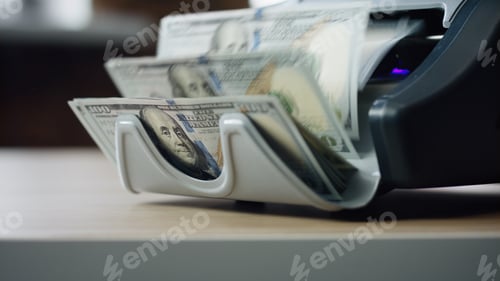 Preview: Machine counting dollar bills close up. Equipment for paper money calculation.