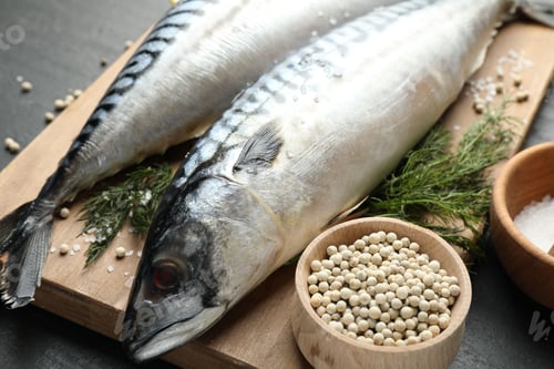 Preview: Fresh raw mackerels and spices on black table, closeup. Seafood delicacies