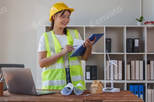 Preview: Female engineer reviewing construction plans for green energy
