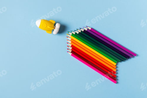 Preview: Back to school theme with colorful pencils and rocket on blue background
