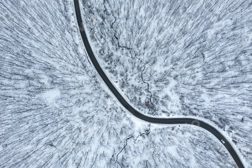 Preview: Winter winding asphalt road in the forest. Aerial drone above view