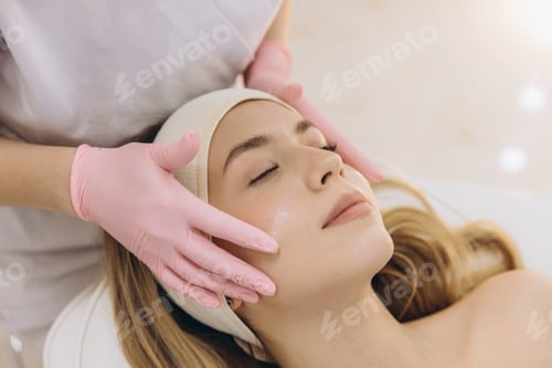 Preview: Skincare professional gently applying hydrating facial cream, providing nurturing treatment