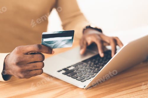 Preview: Afro manager making purchases using laptop computer