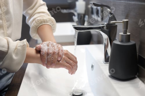Preview: Woman washing hands in bathroom, closeup view