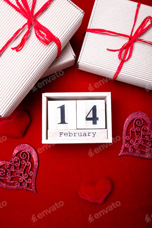 Preview: Wooden calendar show of February 14 with red heart and gift boxes.