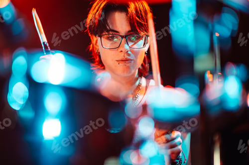 Preview: Drummer playing drums during live performance with bokeh effect