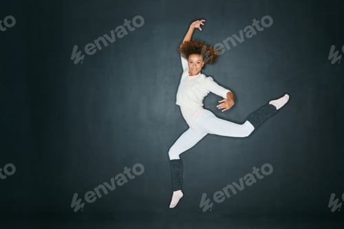 Preview: Studio shot of an attractive young woman dancing against a gray background