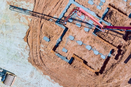 Preview: Builder is using a concrete pump to pour wet concrete into house foundation.