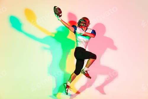 Preview: American football player isolated on gradient studio background in neon light with shadows