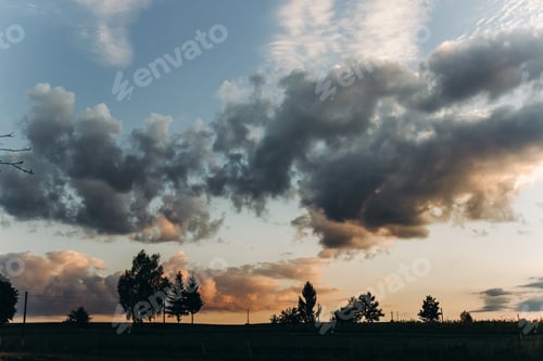 Preview: amazing sunset light through clouds in sky in summer