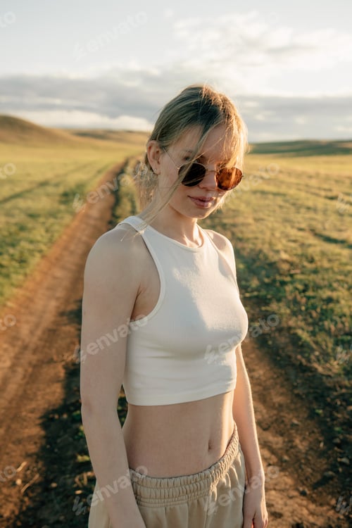 Preview: portrait of beautiful woman walking on field at sunset