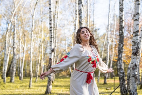 Preview: beautiful woman in ukrainian national traditional costume clothes dancing in forest