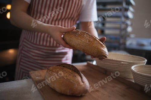 Preview: Close-up of baker with fresh bread in bakery.