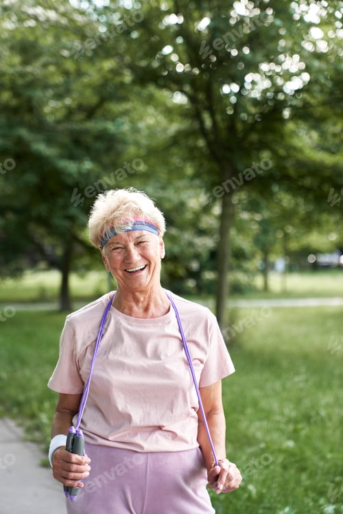 Preview: Active senior woman holding rope in the park