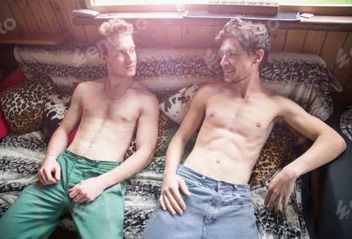 Preview: Two friends relaxing and sharing a laugh on a cozy couch with eclectic cushions.