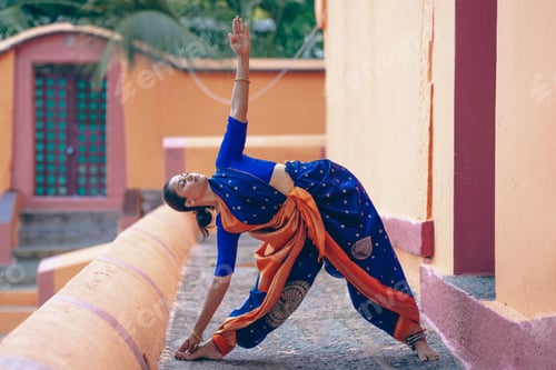 Preview: South asian yogini in sari doing asana in an ancient temple.