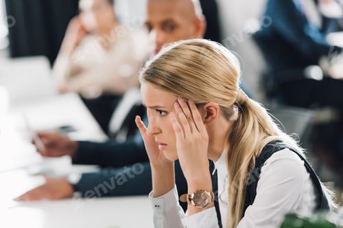 Preview: side view of stressed young businesswoman looking away in office