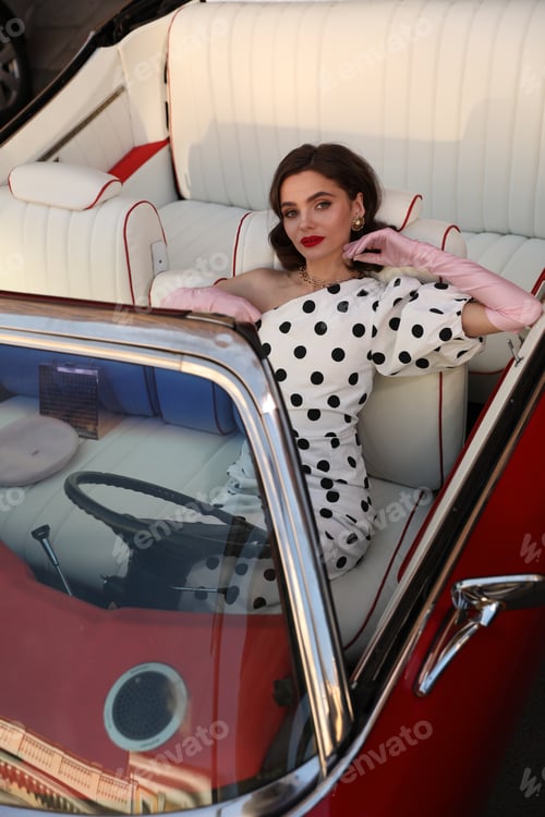 Preview: A fashion woman sits in the red car with white inner saloon