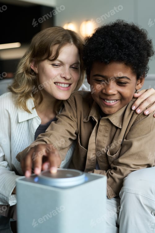 Preview: Family Engaging with Smart Home Assistant Device Smiling Together
