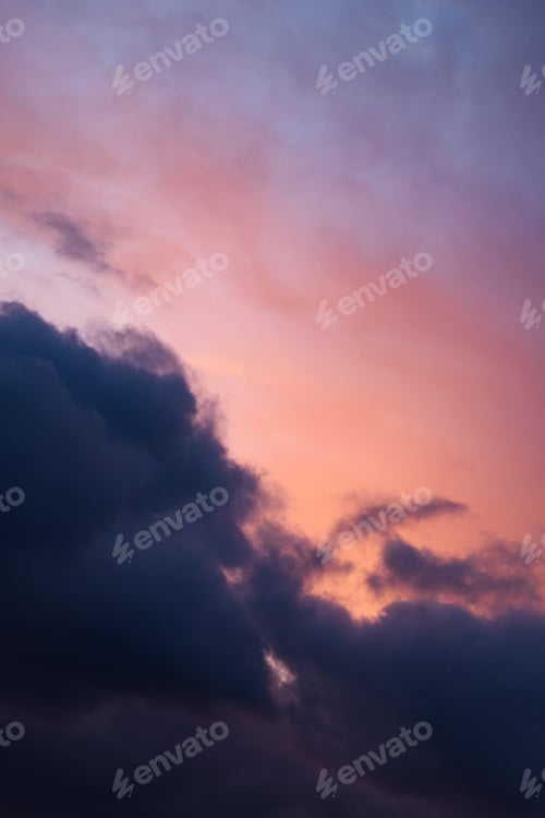 Preview: Vertical photograph of pink, blue clouds in overcast weather at sunset. Romantic sky.