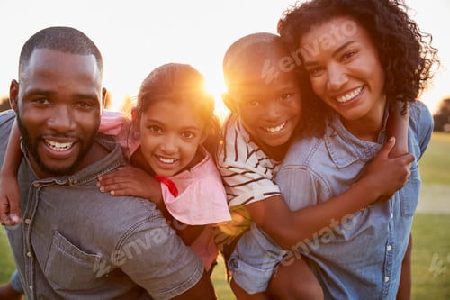 Preview: Happy Family Enjoying Piggyback Ride at Golden Hour
