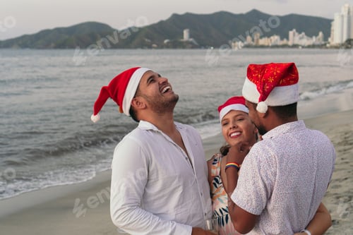 Preview: Friends wearing santa hats enjoying christmas vacation on beach