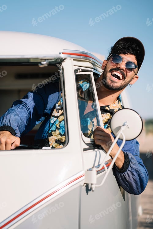 Preview: Cheerful man leaning out car window
