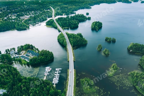 Preview: Aerial view of road bridge with cars between green forests and blue lakes in rural Finland