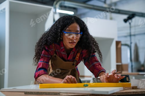 Preview: Woman working as carpenter in a small carpentry workshop