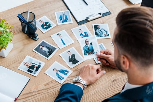 Preview: selective focus of recruiter holding photo of african american man on wooden table