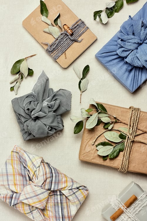 Preview: Trendy gift box wrapped in traditional Japanese furoshiki style on linen background.