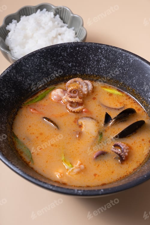 Preview: Tom yum soup and rice on a gray background angle view