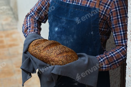 Preview: Fresh loaf of homemade rye bread in woman hands