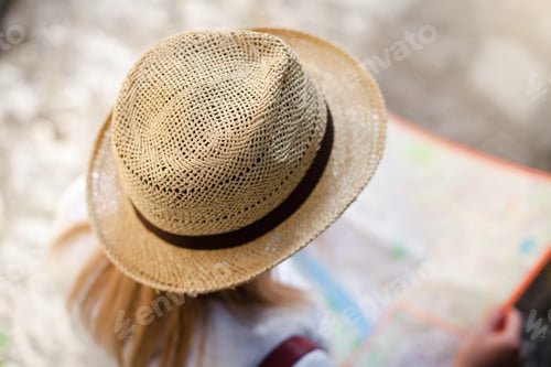 Preview: Woman traveler is looking at city map at town street