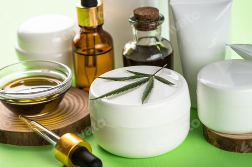 Preview: Cannabis cosmetic products on green background close up.