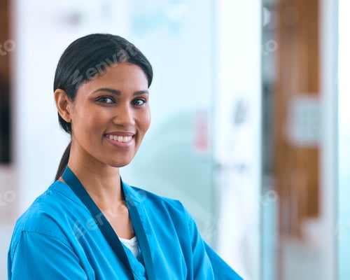 Preview: Head And Shoulders Portrait Of Smiling Female Doctor Or Nurse Wearing Scrubs In Hospital