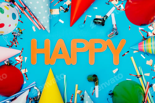 Preview: top view of confetti spilling out of paper cup on white wooden table