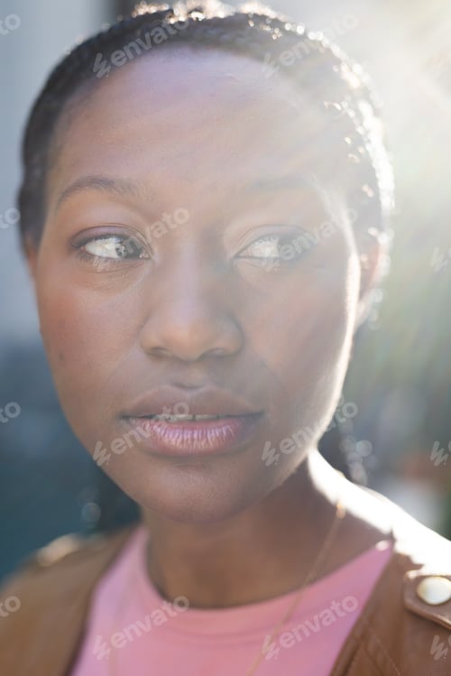 Preview: Sunlight over african american woman looking away, standing outside house
