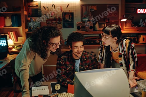 Preview: Happy young people working on computer in team