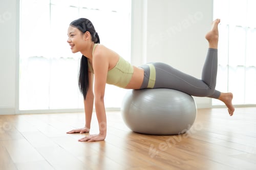 Preview: Young asian woman exercising with fitness ball